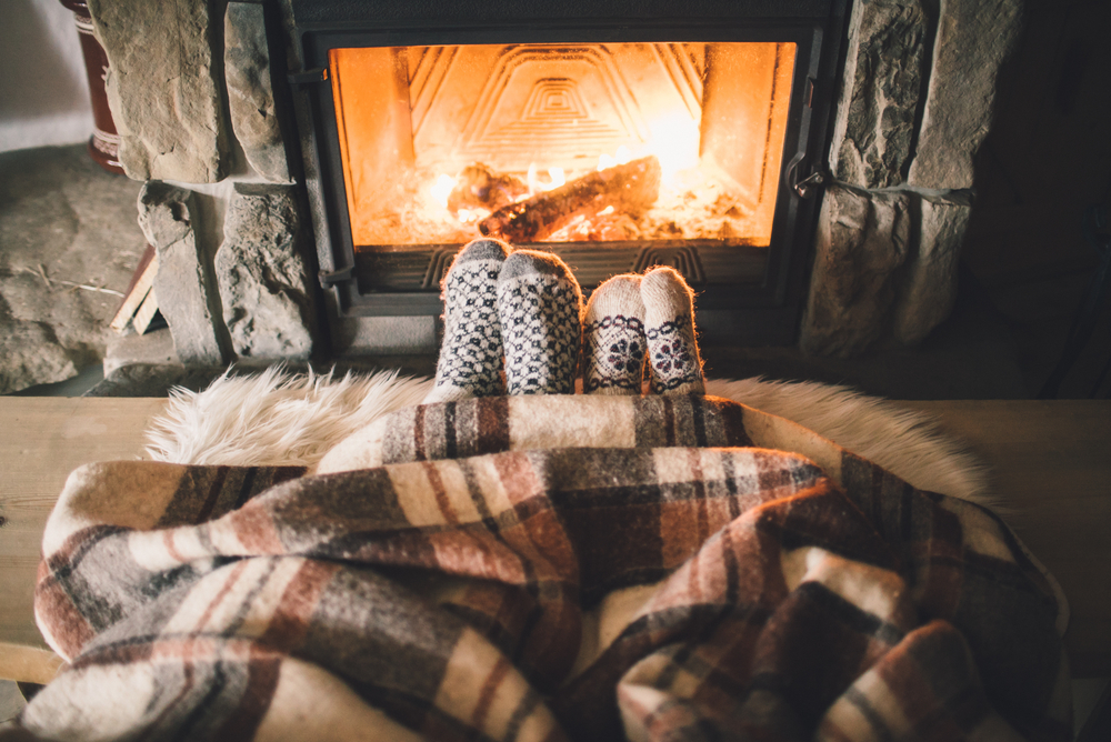 Feet in woollen socks by the Christmas fireplace.